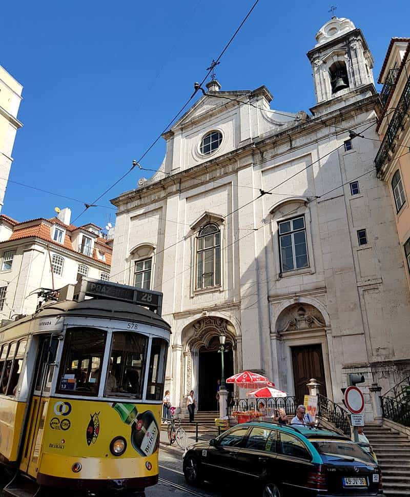 Lisbon yellow tram in front of Church of Saint Mary Magdalene