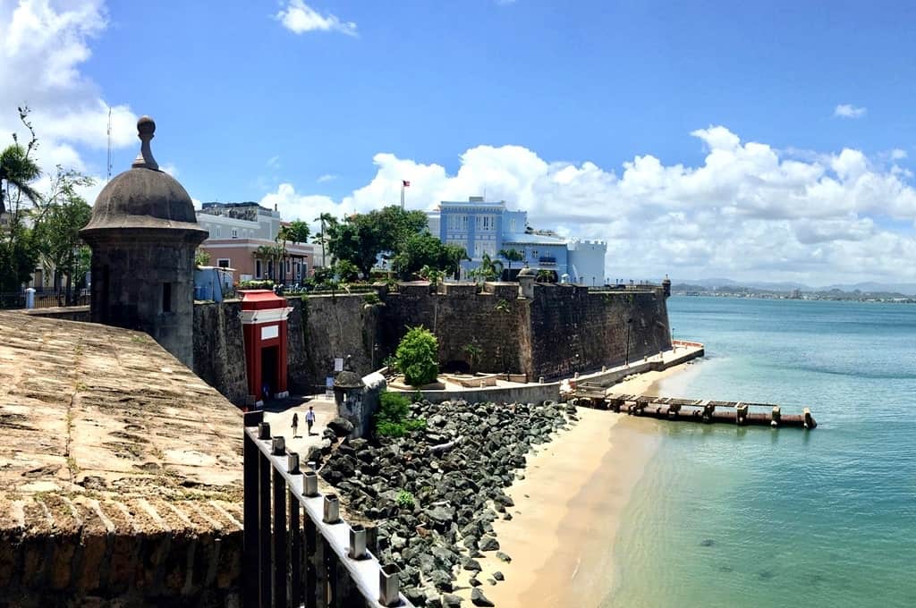 Castillo San Felipe del Morro with the view of La Fortaleza (blue building in the distance and red Puerta San Juan. Photo courtesy of Rene Cicero. 